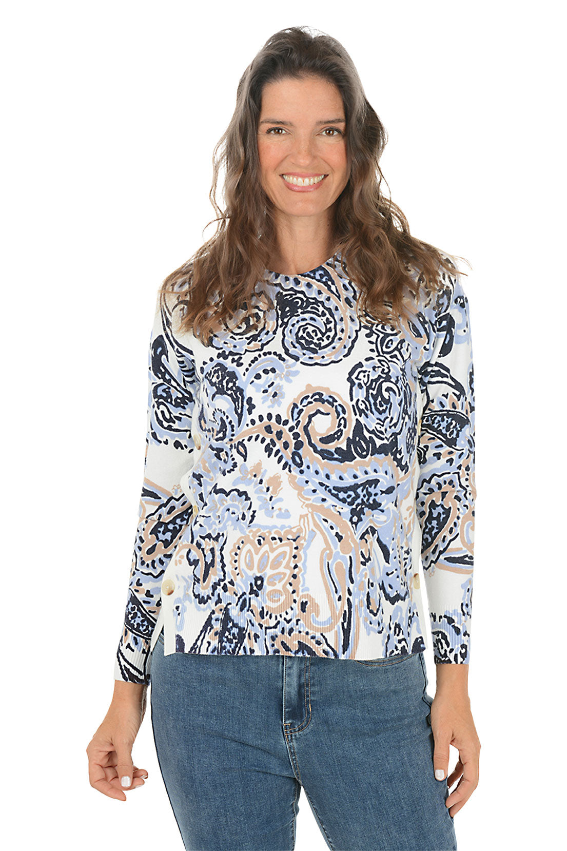 Woman wearing a blue paisley patterned sweater and jeans on a white background.