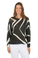 Woman wearing a black and white patterned sweater on a white background.