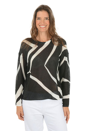 Woman wearing a black and white patterned sweater on a white background.
