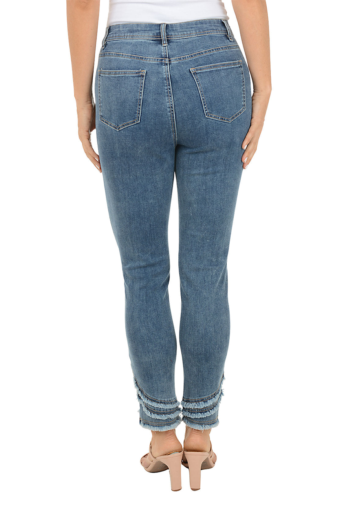 A woman wearing a blue denim ankle pant with three tiers of fringe on the hemline. Back shot.