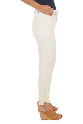 A woman wearing a beige ankle pant with three tiers of fringe on the hemline. Side shot.