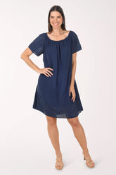 Woman wearing a navy blue dress with lace details on a white background