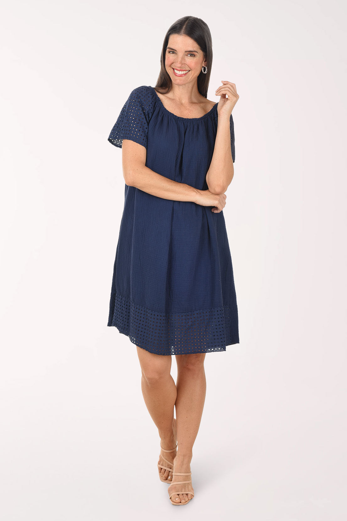 Woman wearing a navy blue dress with lace details on a white background