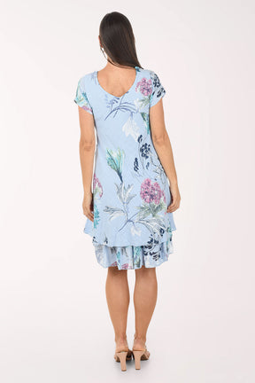 Woman wearing a light blue floral dress on a white background