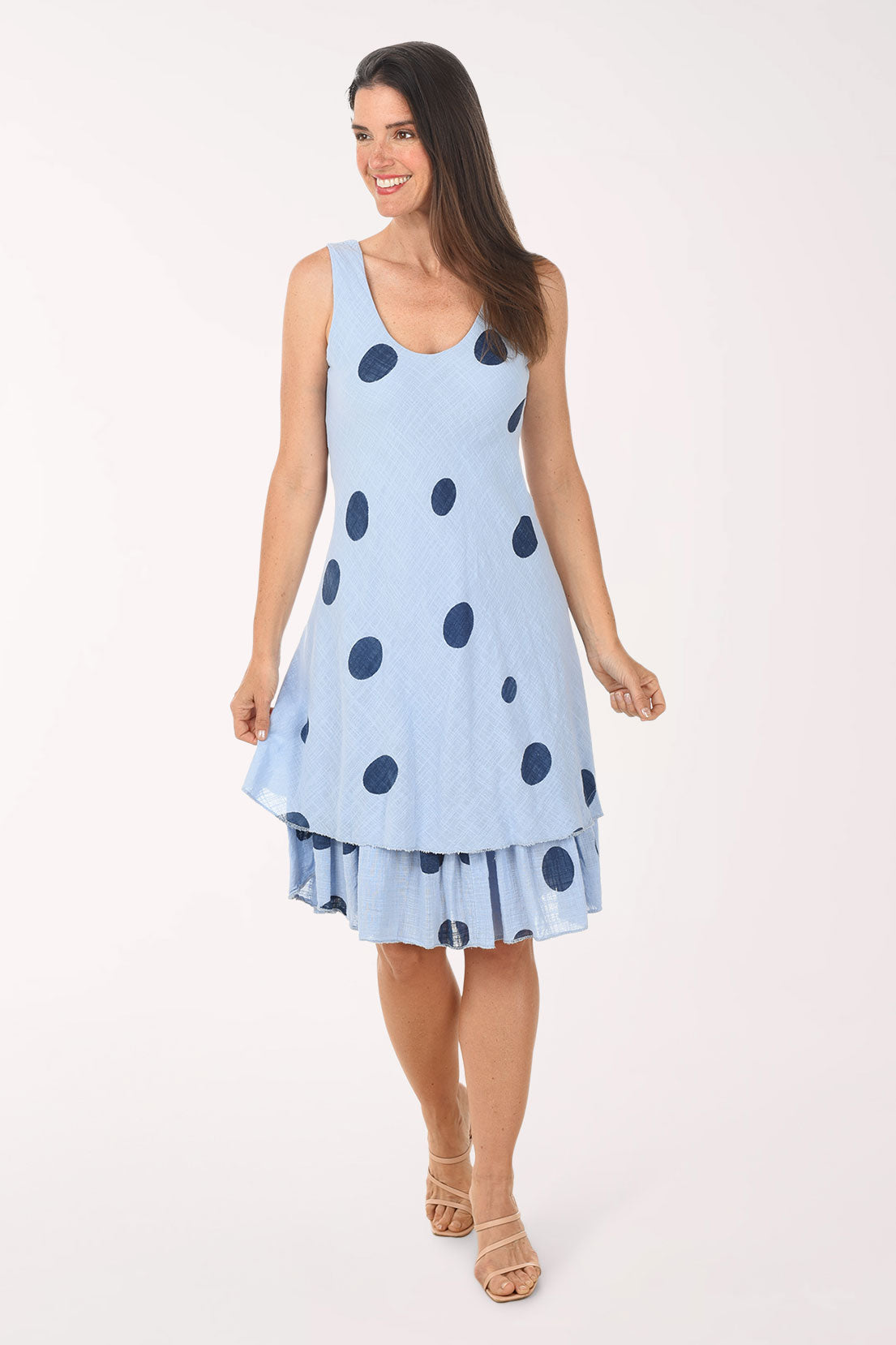 Woman wearing a light blue dress with dark polka dots on a white background