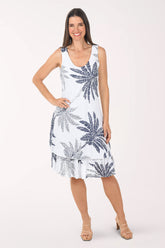 Woman wearing a white dress with blue palm tree patterns on a white background