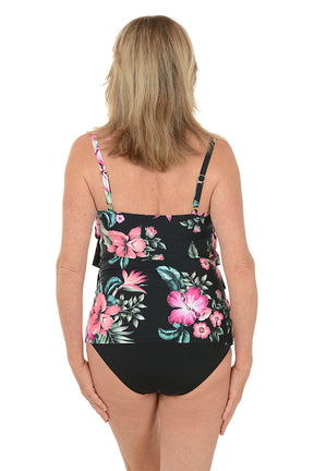 Woman wearing a black floral tankini top on a white background. Back shot.