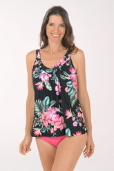 Woman wearing a black floral tank top and pink shorts on a white background.
