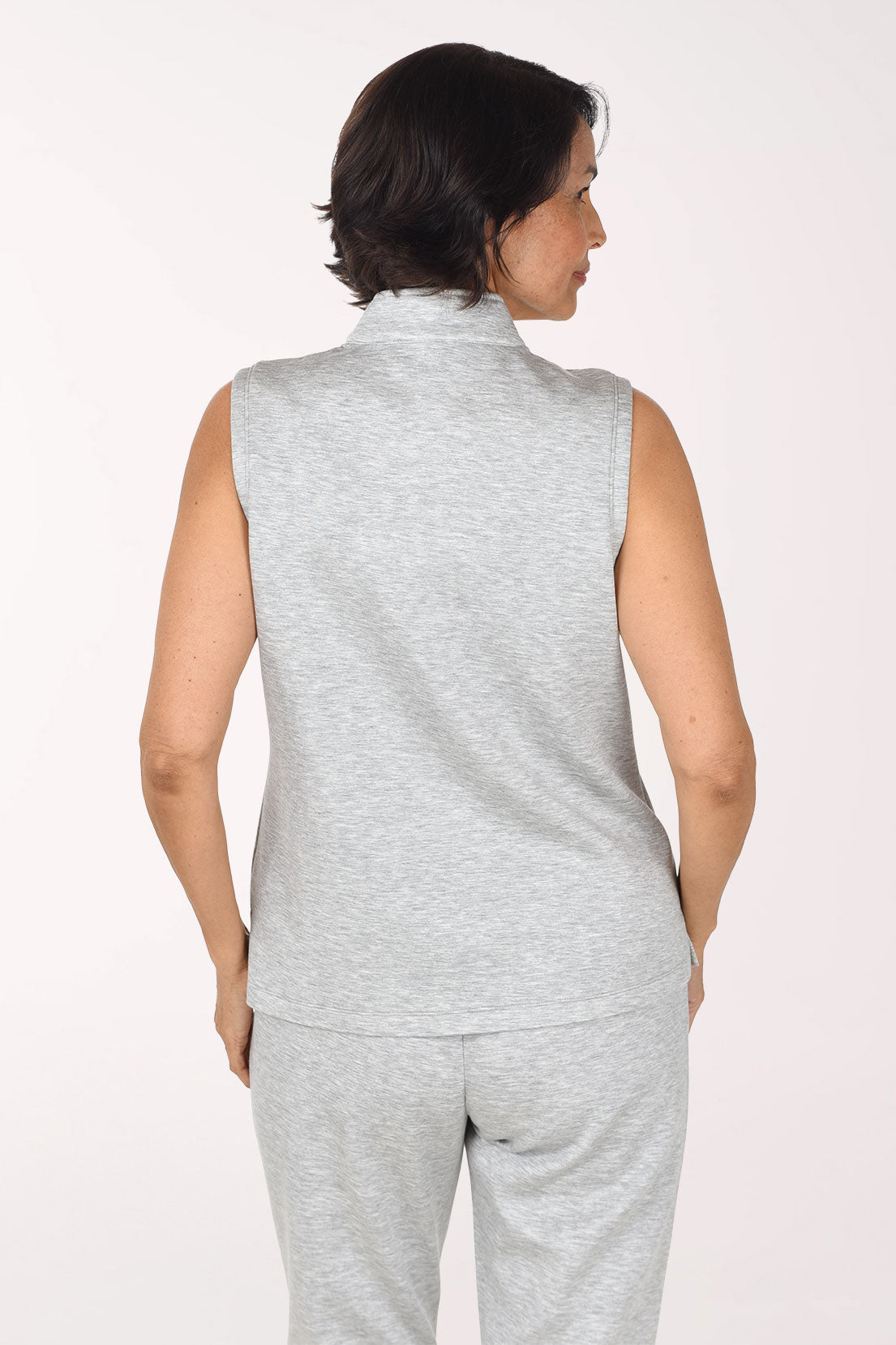 Back view of the light heather grey scuba sleeveless quarter zip top showing the stand-up collar and straight hem.