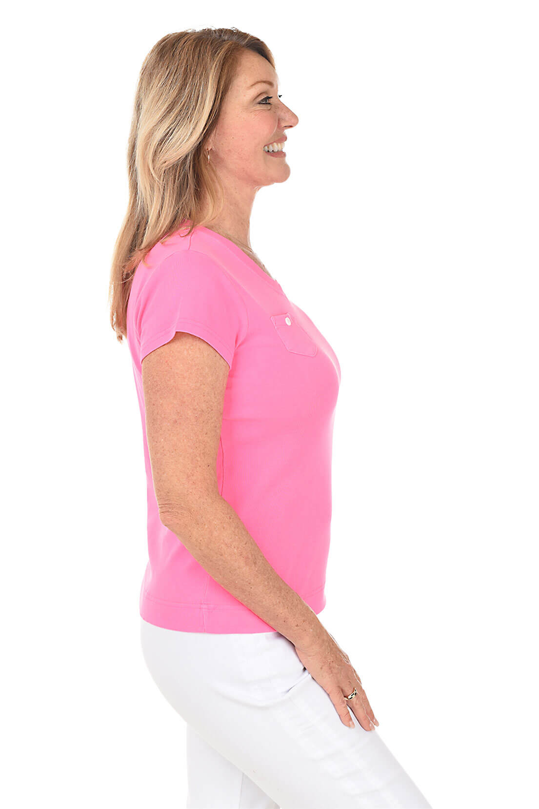 Woman wearing a bright pink shirt with a white background. Side shot