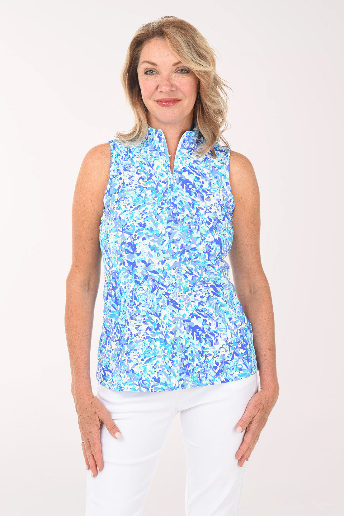 Woman wearing a blue floral sleeveless top against a white background
