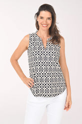 Woman wearing a sleeveless black and white patterned top on a white background