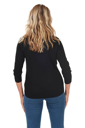 Back shot of a woman wearing a black cardigan over a white top and blue jeans on a white background