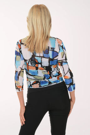 Woman wearing a colorful patterned jacket over a black top on a white background
