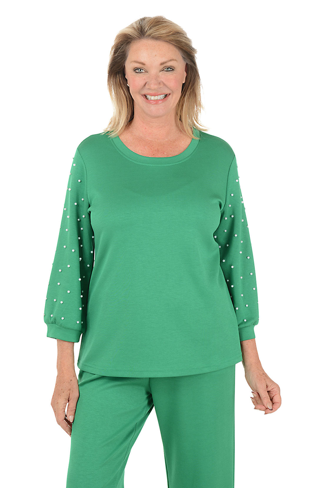 Woman wearing a green outfit with polka dot sleeves on a white background.