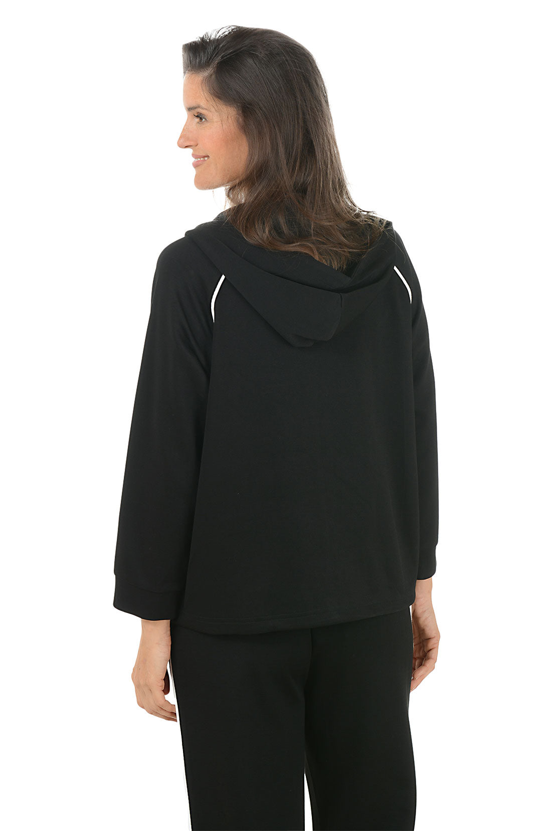 Woman wearing a black hoodie with white accents on a white background. Back shot.