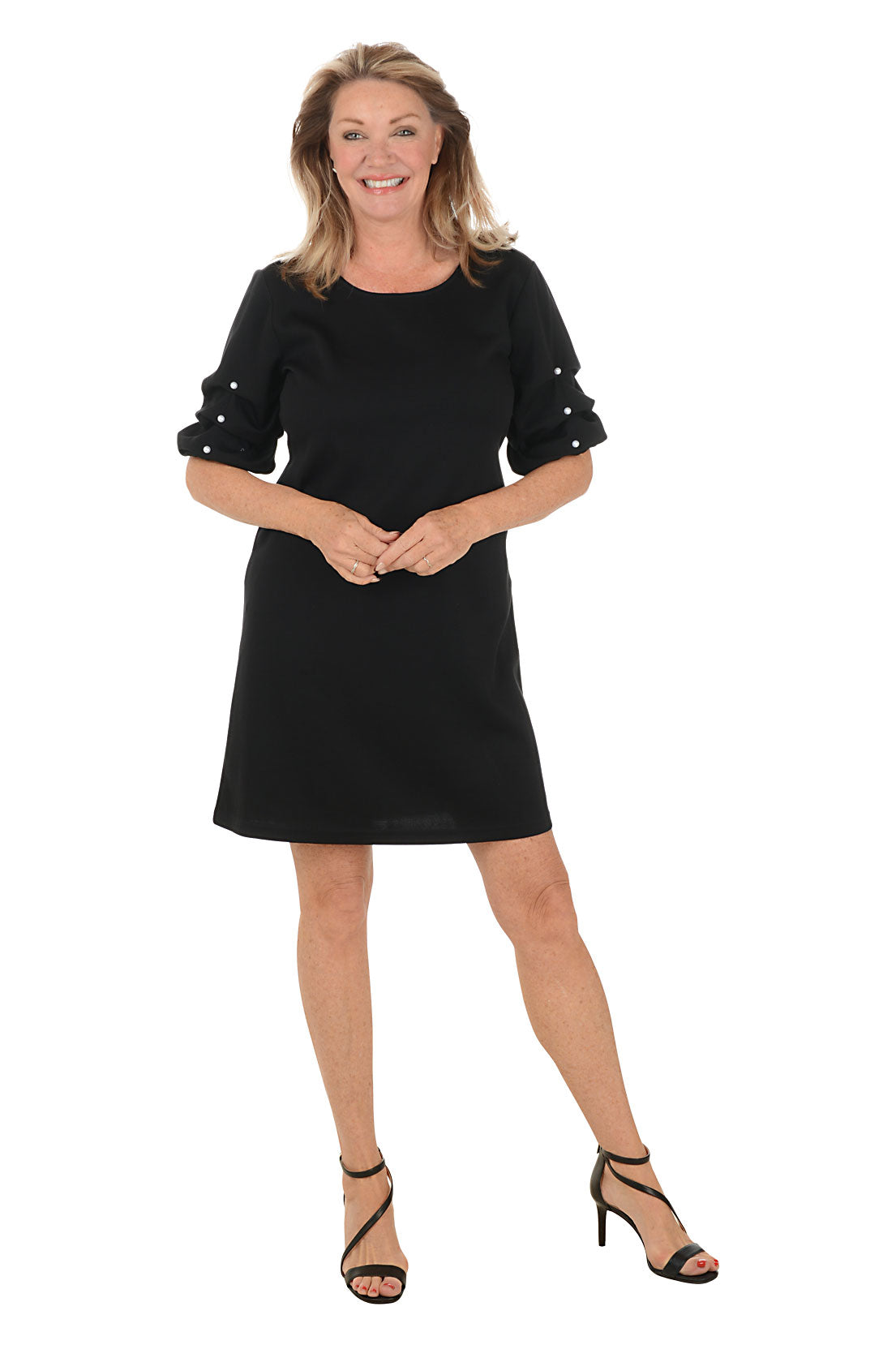 Woman wearing a black dress with ruffled sleeves on a white background