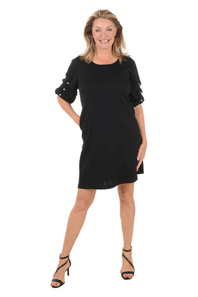 Woman wearing a black dress with ruffled sleeves on a white background