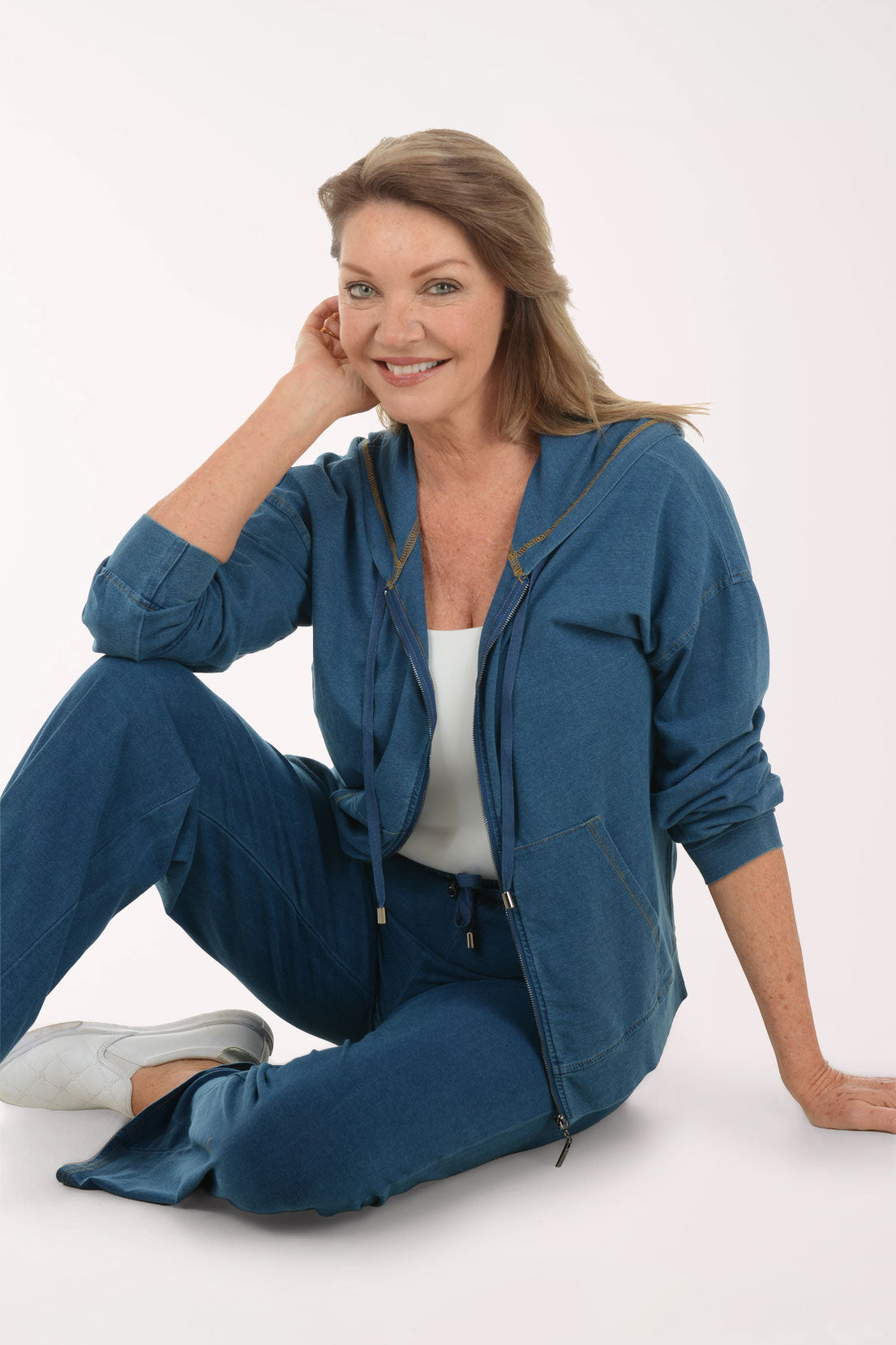 Woman wearing a blue hoodie and pants on a white background
