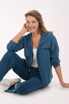 Woman wearing a blue hoodie and pants on a white background