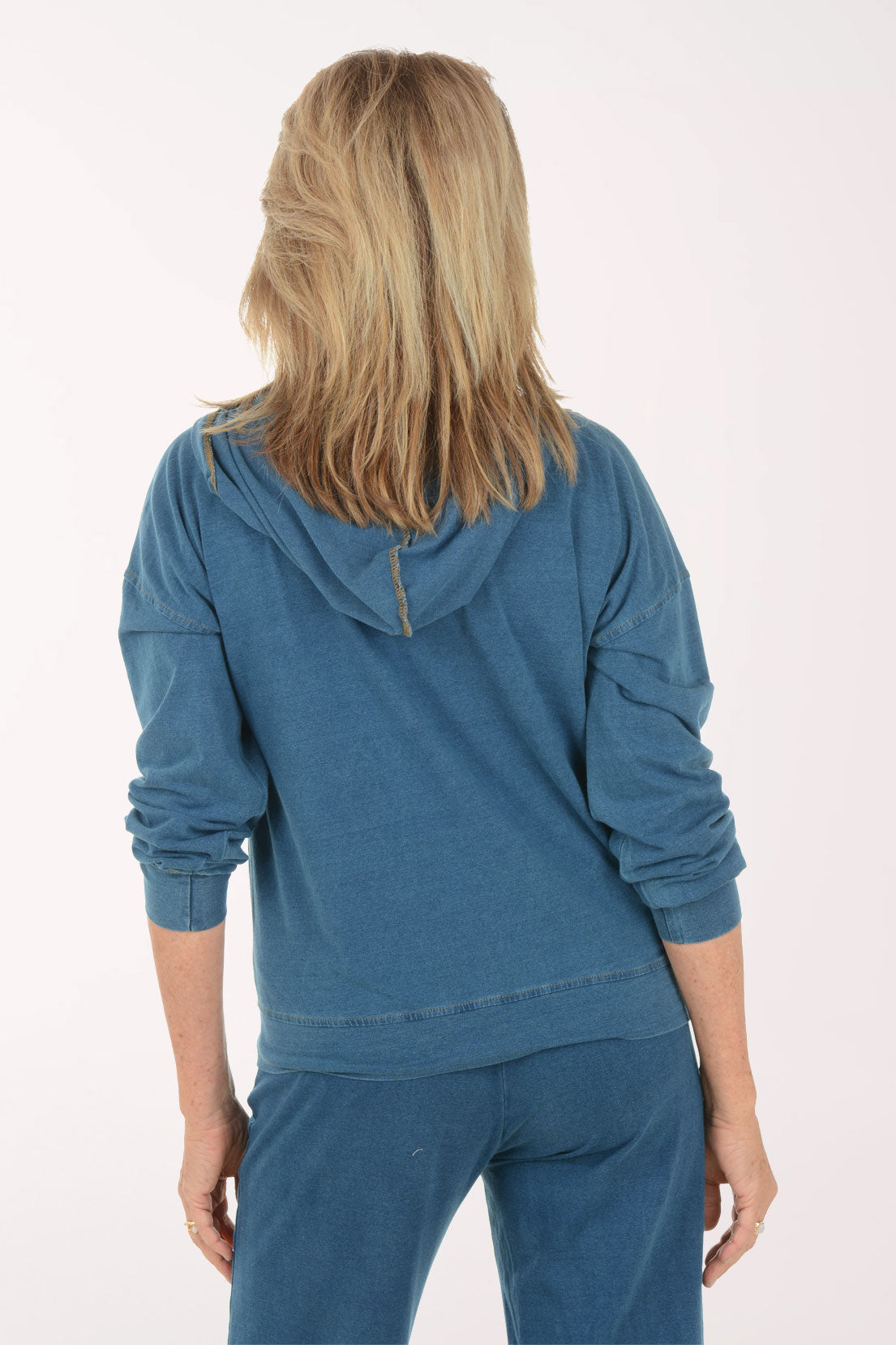 Woman wearing a blue hoodie and pants on a white background