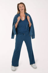 Woman wearing a blue outfit with a matching jacket on a white background