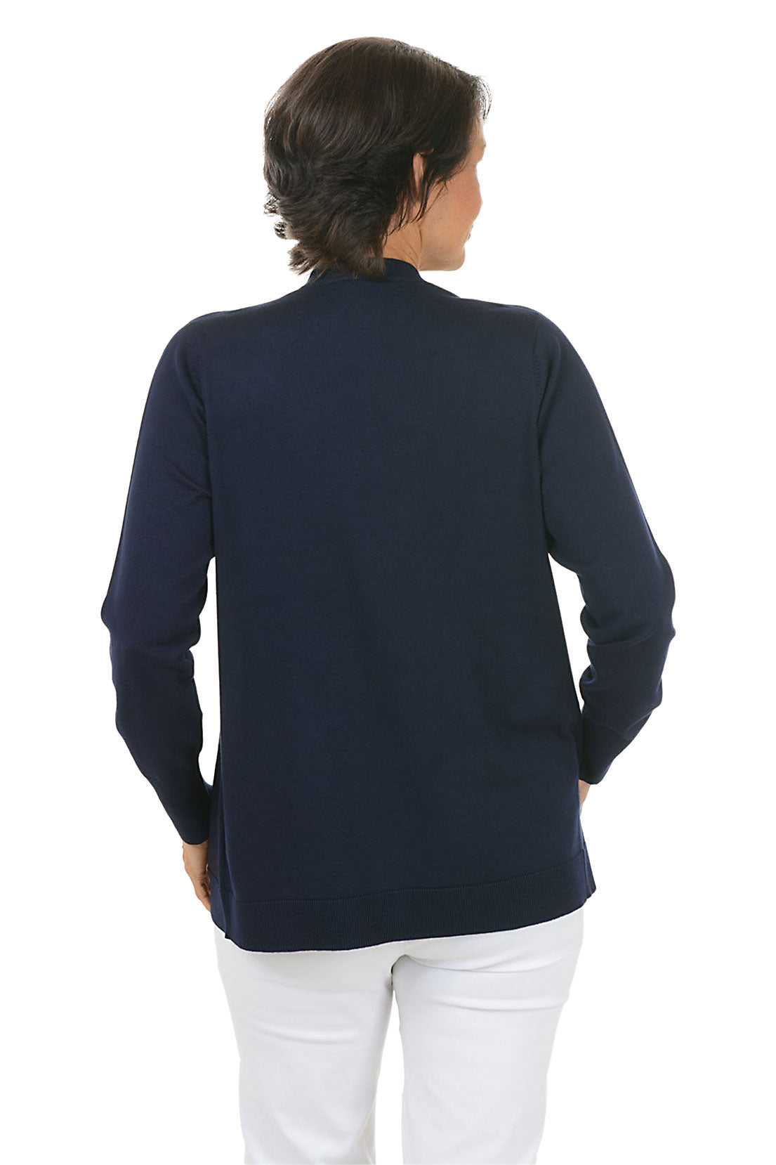 Woman wearing a navy cardigan with white pants on a white background. Back shot.