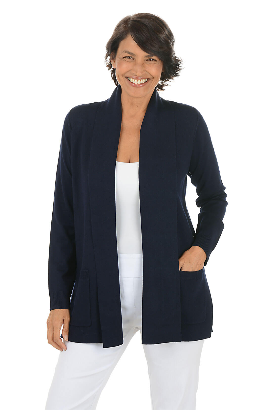 Woman wearing a navy cardigan over a white top and pants on a white background