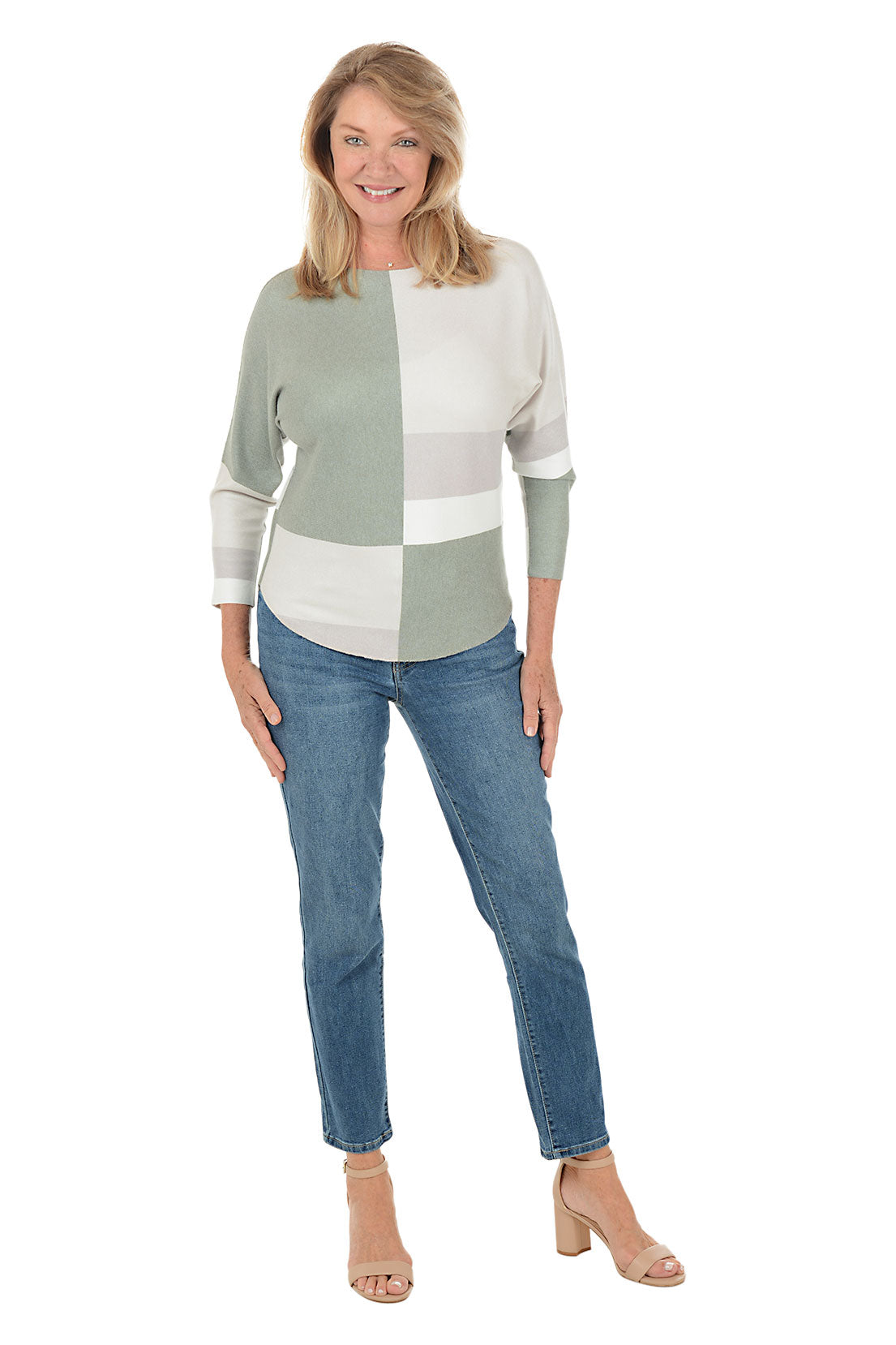 Woman wearing a color-blocked top and jeans on a white background.