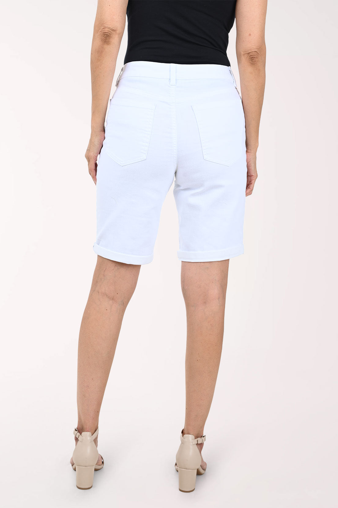 Person wearing white bermuda shorts on a white background