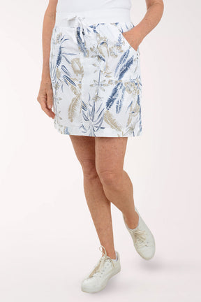 Person wearing a white floral skirt on a plain background