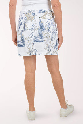 Person wearing a white floral skirt on a plain background