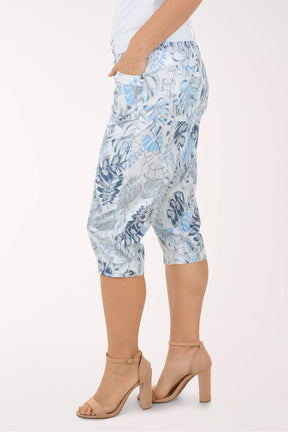 Woman wearing blue and white leaf printed capri pants.
