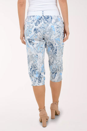 Woman wearing blue and white leaf printed capri pants.