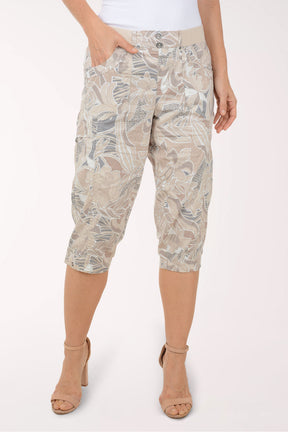 Woman wearing brown and grey leaf printed capri pants.
