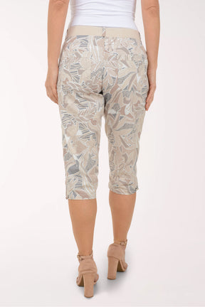 Woman wearing brown and grey leaf printed capri pants.