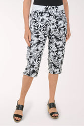 Woman wearing black and white leaf printed capri pants.