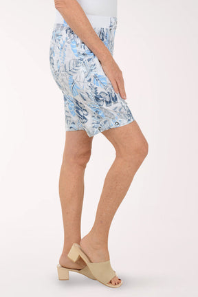 Person wearing a blue floral skirt on a white background