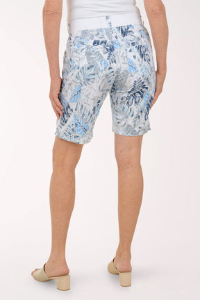 Person wearing blue floral shorts on a white background