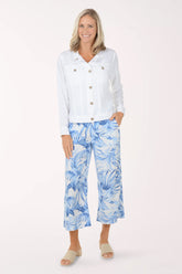 Woman wearing a white shirt and blue floral pants on a white background
