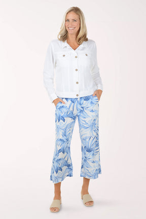 Woman wearing a white shirt and blue floral pants on a white background