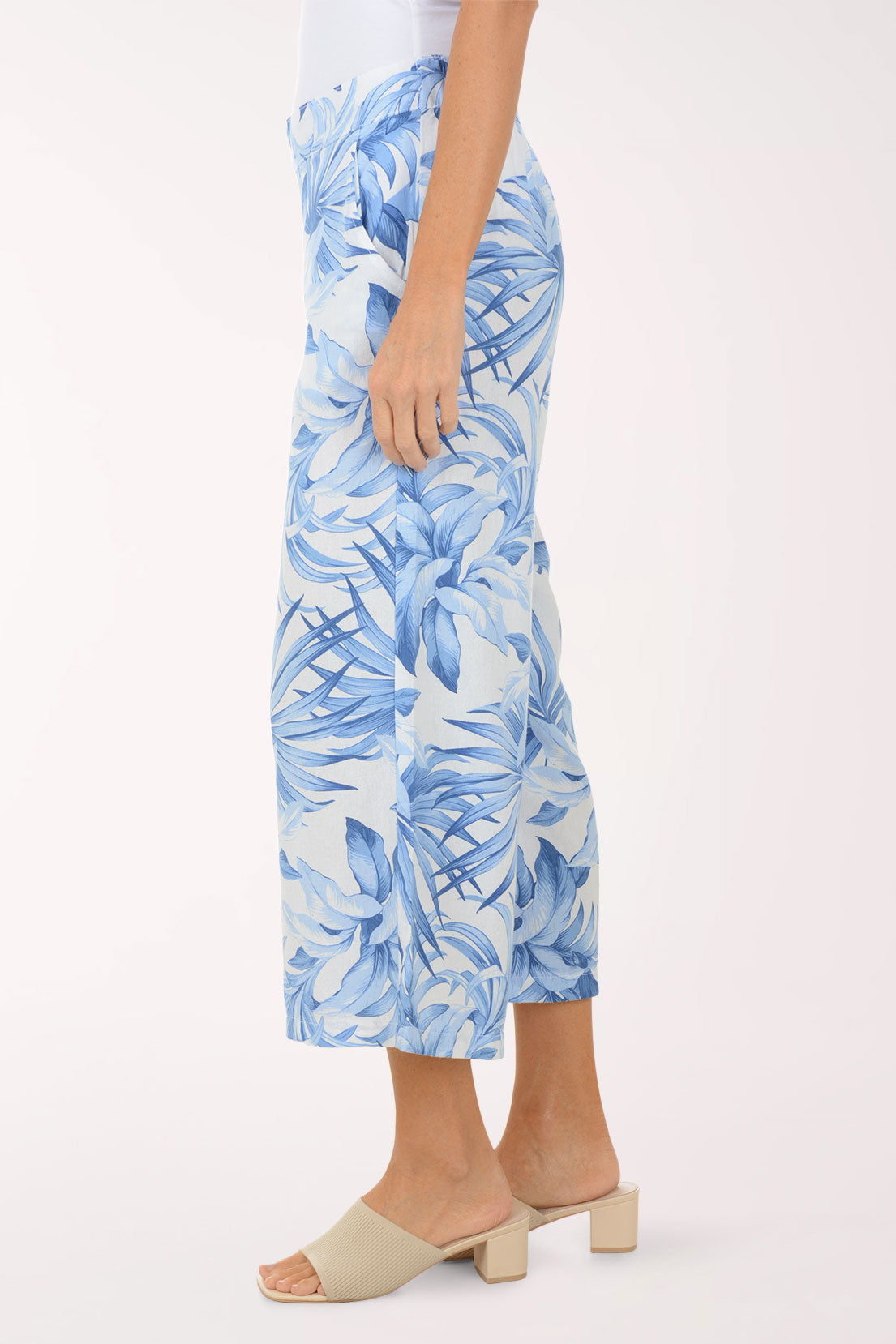 Person wearing blue tropical print pants on a white background