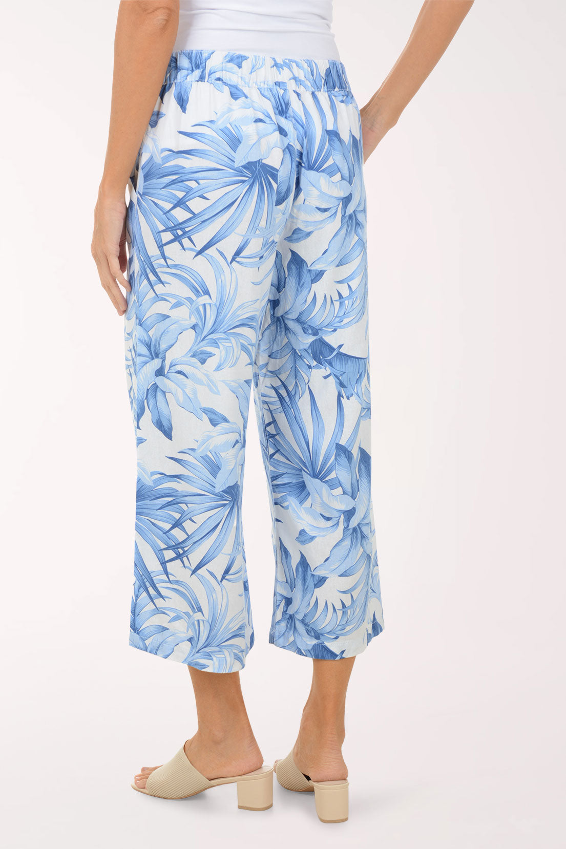 Person wearing blue tropical print pants on a white background