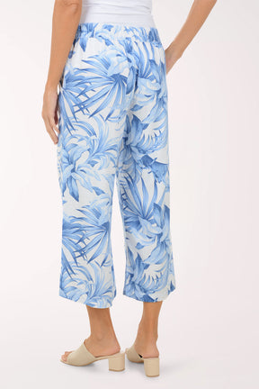 Person wearing blue tropical print pants on a white background