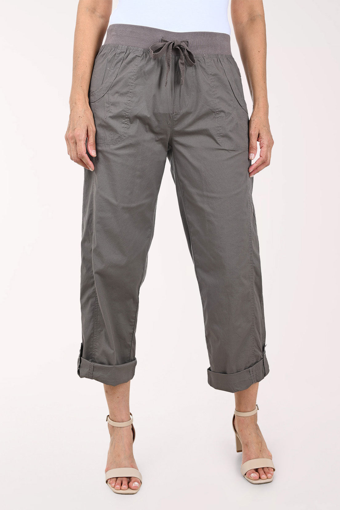 A person wearing dark gray drawstring cropped pants with rolled cuffs, shown from the waist down against a plain light background.