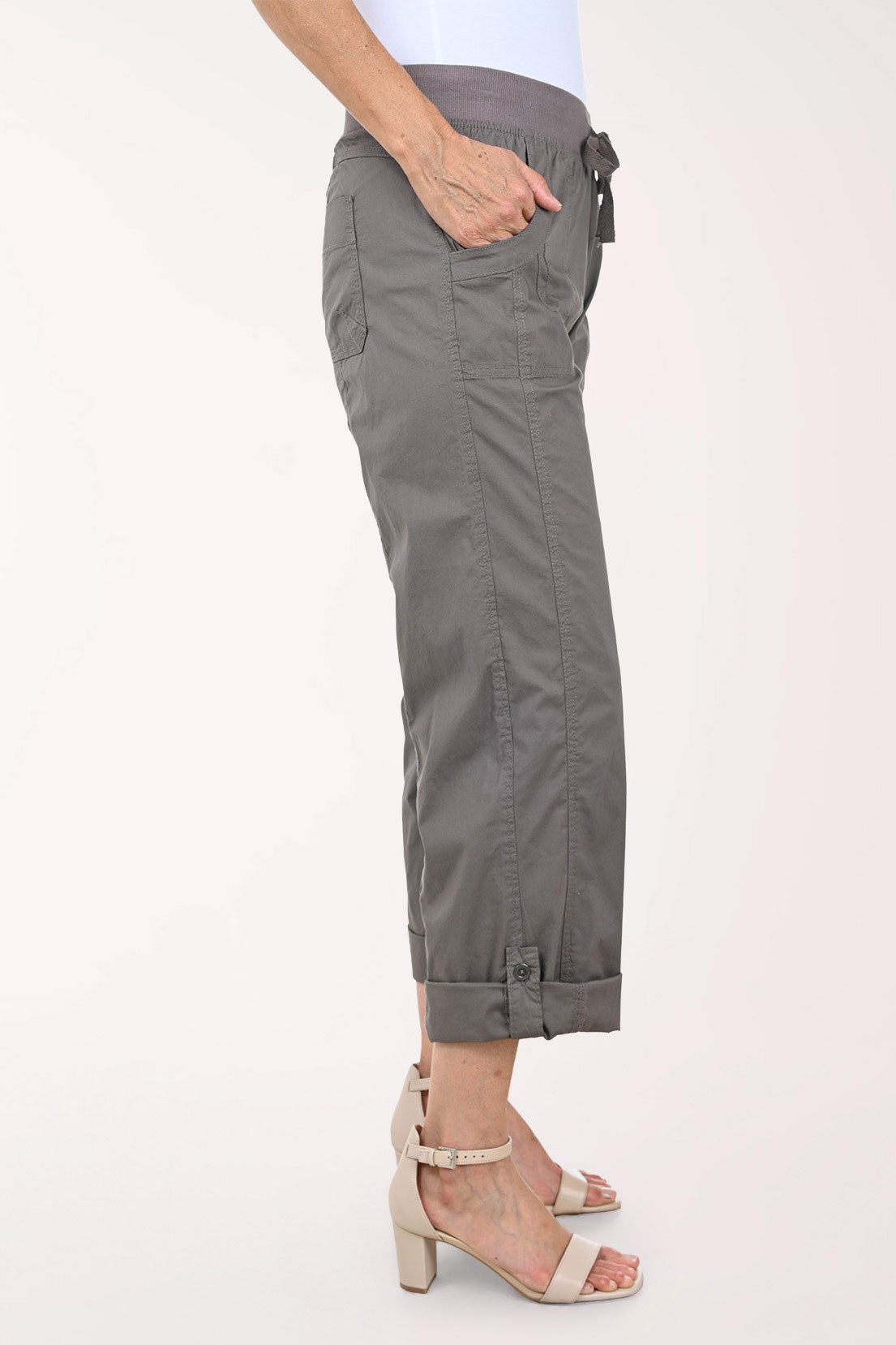 A person wearing dark gray drawstring cropped pants with rolled cuffs, shown from the waist down against a plain light background.