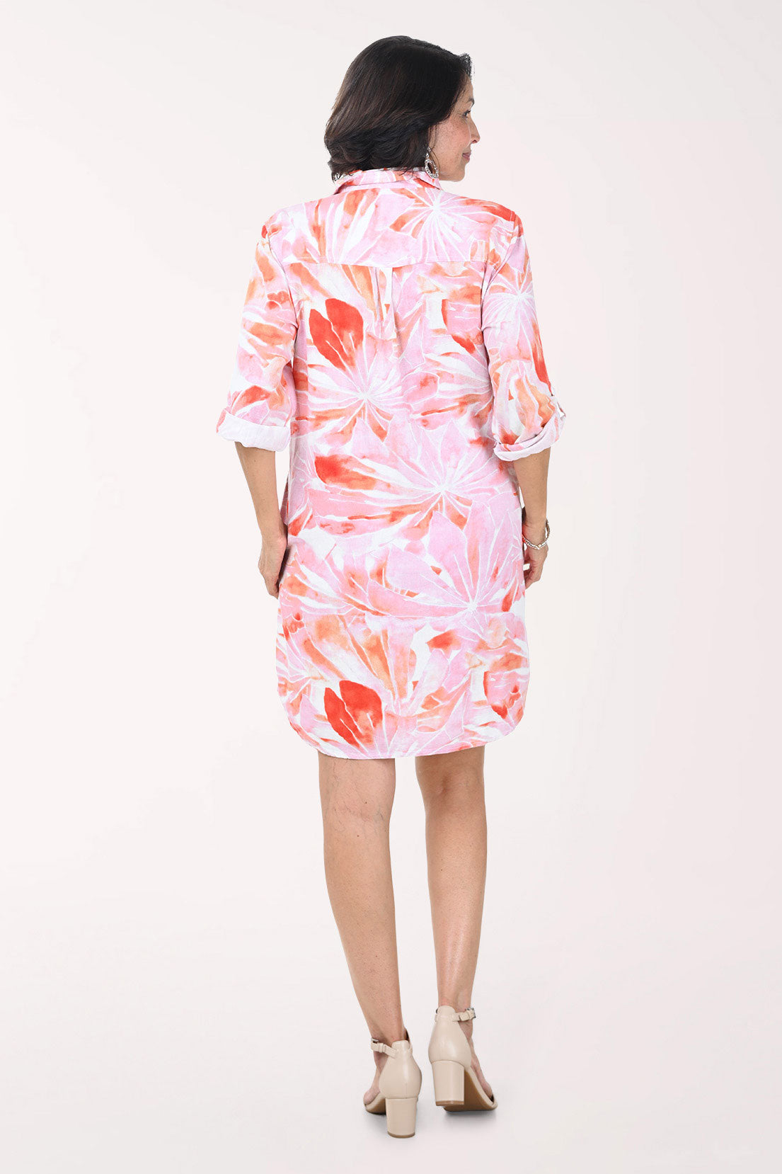 Woman wearing a pink floral dress on a white background