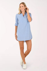 Woman wearing a blue and white striped shirt dress on a white background