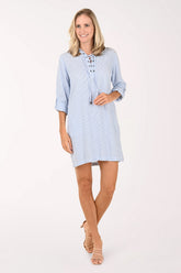 Woman wearing a light blue dress with rolled-up sleeves on a white background
