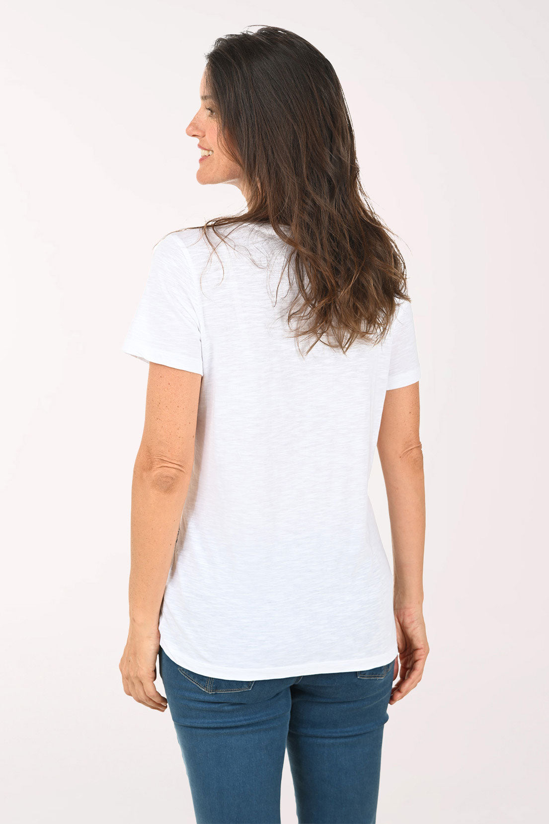 Woman wearing a white top with a palm tree pattern